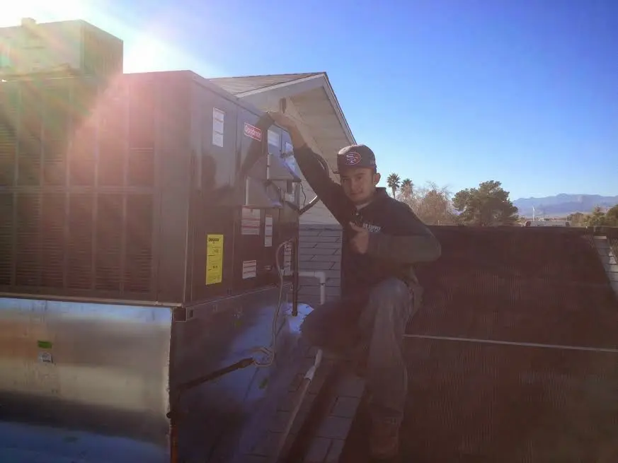 HVAC technician performing HVAC Inspection on a rooftop unit in Providence